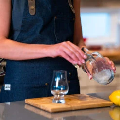 The Apres Supply Co. The Denim BBQ Apron - Recycled Cotton Denim With Leather Trim -Kitchen BBQ Sale The Apres Supply Co The Denim BBQ Apron Recycled Cotton Denim with Leather Trim Lifestyle